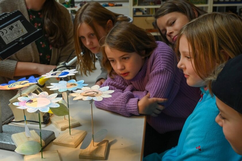Wie Kinder Nachhaltigkeit kennenlernen - Schüler der Pablo-Neruda-Grundschule bastelten unter Anleitung von Mitarbeitern wie Tina Gräßler (links) eine Blume, die sich mit Solarenergie in Bewegung setzt. 
