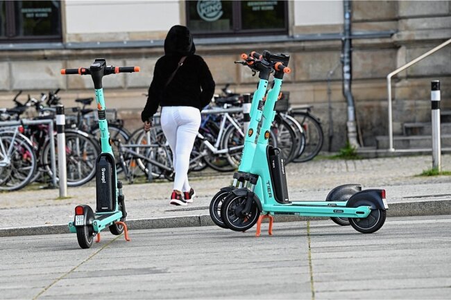 Wie man in Chemnitz einen E-Scooter mietet - Geparkte Tier-Elektroroller neben dem Chemnitzer Hauptbahnhof. Die E-Scooter dürfen nur aufrecht am Rand geparkt werden, sodass der Weg nicht blockiert wird. 