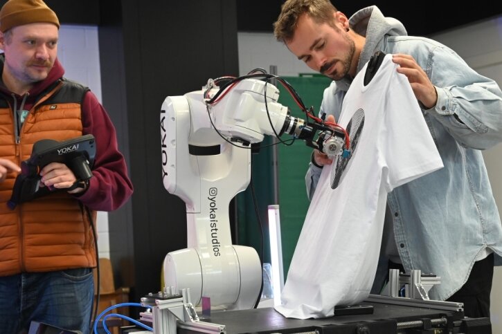 Wie Roboter lernen, T-Shirts zu fertigen - Viktor Weichselbaumer und Michael Wieser (von links), die das Yokai-Studio bilden, lassen ein T-Shirt vom Roboter bedrucken. 