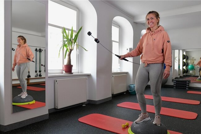 Übungsleiterin Christin Walter vom Fitnessstudio "Aktiv am Dom" in Freiberg demonstriert eine Schwingstab-Übung im Kursraum, die auch im Rehasport trainiert wird.