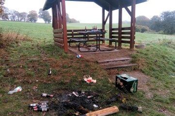 Wie Vandalismus die Kommunen im Vogtland vor Probleme stellt - Verwüstung im Oktober 2021 an der Wanderschutzhütte bei Obermylau. Weidezaun-Pfähle wurden verbrannt, Flaschen lagen kreuz und quer.