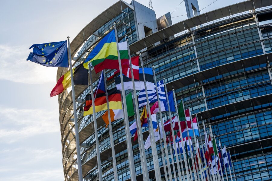 Wie viel Macht hat das EU-Parlament? - Die Flaggen der Europäischen Union, der Ukraine und der Mitgliedsstaaten der EU vor dem Gebäude des Europäischen Parlaments in Straßburg.