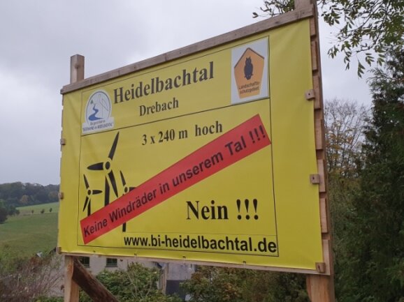 Gegenwind kontra Aufwind. Die gelben Plakate der Windkraftgegner sind im Kreis schon in einigen Orten - hier in Drebach - zu finden.