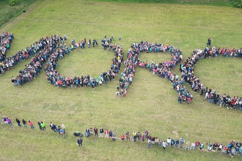 Wo junge Leute als Macher Farbe ins Rochlitzer Stadtleben bringen - Mit einem Flashmob im September 2019 bildeten rund 1500 Schülerinnen und Schüler den Schriftzug "MORO" - getreu dem Motto der Initiative Motley Rochlitz (Kunterbuntes Rochlitz). 