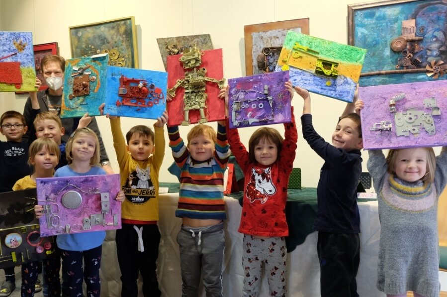 Mädchen und Jungen der Gruppe "Schlaue Füchse" der Kita in der Roten Schule in Oelsnitz zeigen die von ihnen selbst gestalteten Bilder. Dafür verwendeten sie auch Schrottteile.