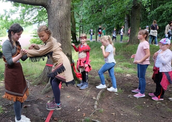 Wo Lugauer Kinder Spiellaune und Abenteuerlust ausleben - Azubi Vanessa Tennert (links) hilft der siebenjährigen Anna beim Überwinden der Slackline, bei der die Kinder ihre Geschicklichkeit bewiesen haben.