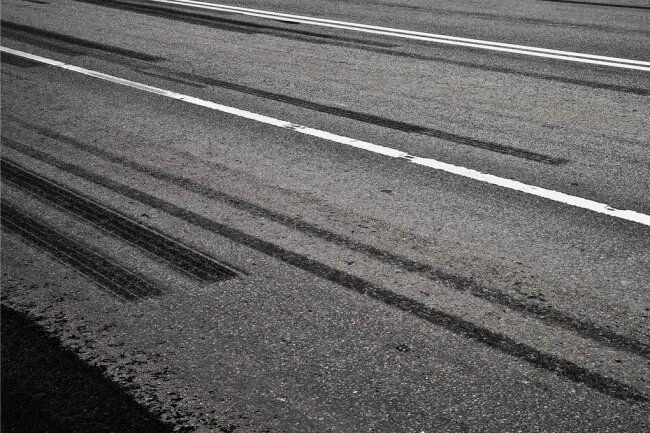 Reifenspuren auf Asphalt: Abruptes Bremsen und kräftiges Beschleunigen erzeugt jede Menge Abrieb. 