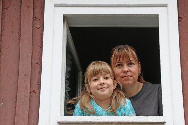 Ines Hermann und Tochter Josefin schauen aus dem Fenster ihrer Unterkunft in Lichtenberg. 