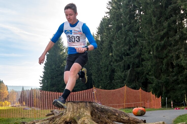 Wurzellauf begeistert 258 Teilnehmer - Mit einem Sprung über die Wurzel, der der Wurzellauf seinen Namen verdankt, kommt Jonas Müller vom ATSV Gebirge/Gelobtland in der Altersklasse U 15 nach fünf Kilometern als Erster ins Ziel. 