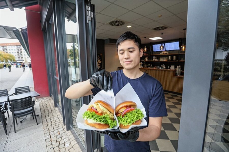 Yumi Kitchen: In Chemnitz gibt's jetzt Burger im Asia-Style - Am Wall in Chemnitz gibt es einen neuen Burgerladen. Manh Bao Nguyen, Koch im Yumi, mit einem Cheeseburger und einem Veggie Tofu Burger. 
