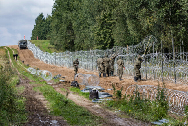 Zäune sind der falsche Weg: Ein Kommentar zur illegalen Einwanderung über Belarus - Polnische Soldaten errichten einen Stacheldrahtzaun entlang der polnisch-belarussischen Grenze.