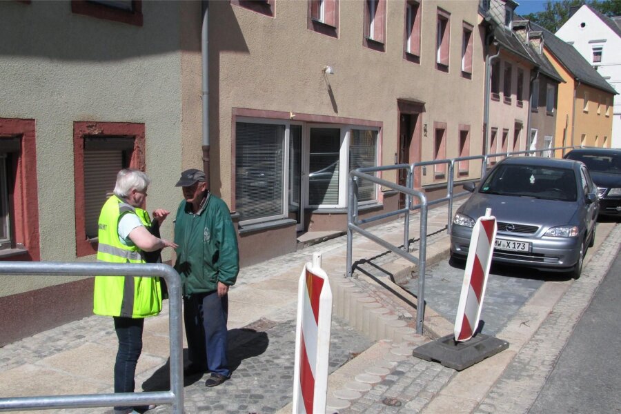 Zeigner-Straße in Geringswalde wieder frei befahrbar - Monika Baumgarten vom Ordnungsamt verständigt sich mit einem der Anwohner über das Gefälle des Gehweges.