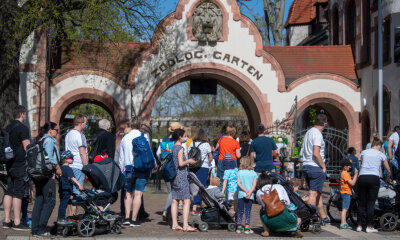 Zoos, Tierparks und Wildgehege in Sachsen: Adressen, Öffnungszeiten, Eintrittspreise - Besucher stehen vor dem Tor zum Zoo Leipzig.