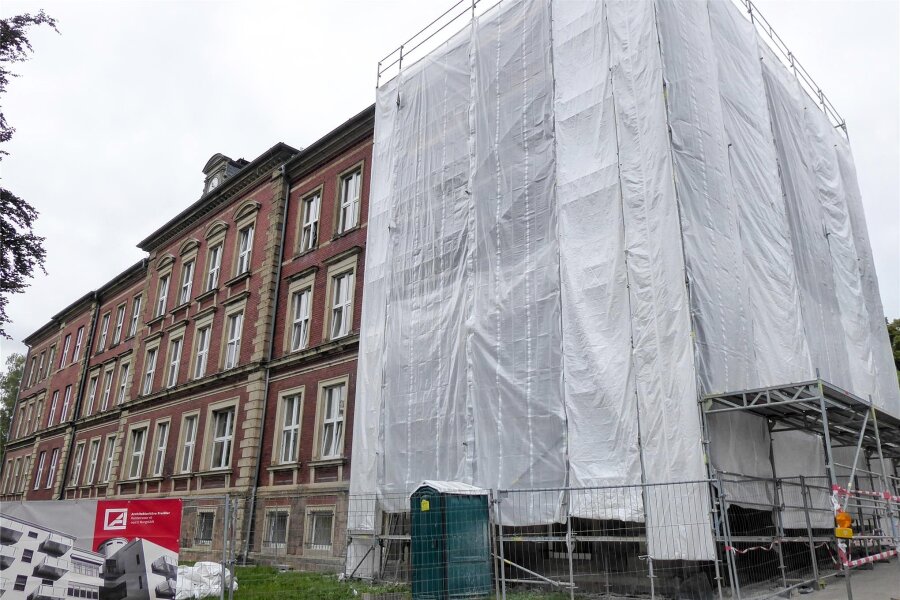 Zu DDR-Zeiten entfernter Schriftzug an Schule in Hartmannsdorf soll wieder sichtbar werden - Das Schulhaus in Hartmannsdoprf zeigt sich derzeit eingerüstet und mit Planen verhüllt. Die Fassade wird saniert.