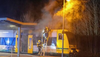 Zug der Vogtlandbahn geht am Bahnhof in Flammen auf - Feuerwehrleute aus Auerbach und Rebesgrün waren rund zweieinhalb Stunden mit dem Löschen des Triebwagens beschäftigt. Zunächst dämmten sie die Flammen mit Wasser ein, dann löschten sie mit Schaum.