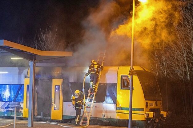 Zug der Vogtlandbahn geht am Bahnhof in Flammen auf - Feuerwehrleute aus Auerbach und Rebesgrün waren rund zweieinhalb Stunden mit dem Löschen des Triebwagens beschäftigt. Zunächst dämmten sie die Flammen mit Wasser ein, dann löschten sie mit Schaum.