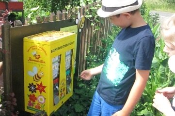 Zuger Kita "Löwenzahn" blüht auf - Der Bienenfutterautomat interessierte die Kinder bei ihrem Besuch im Blumenhaus. 