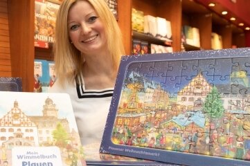 Sophie Gürtler vom Dachverband Stadtmarketing mit dem neuen Puzzle und dem Plauener Wimmelbuch. 