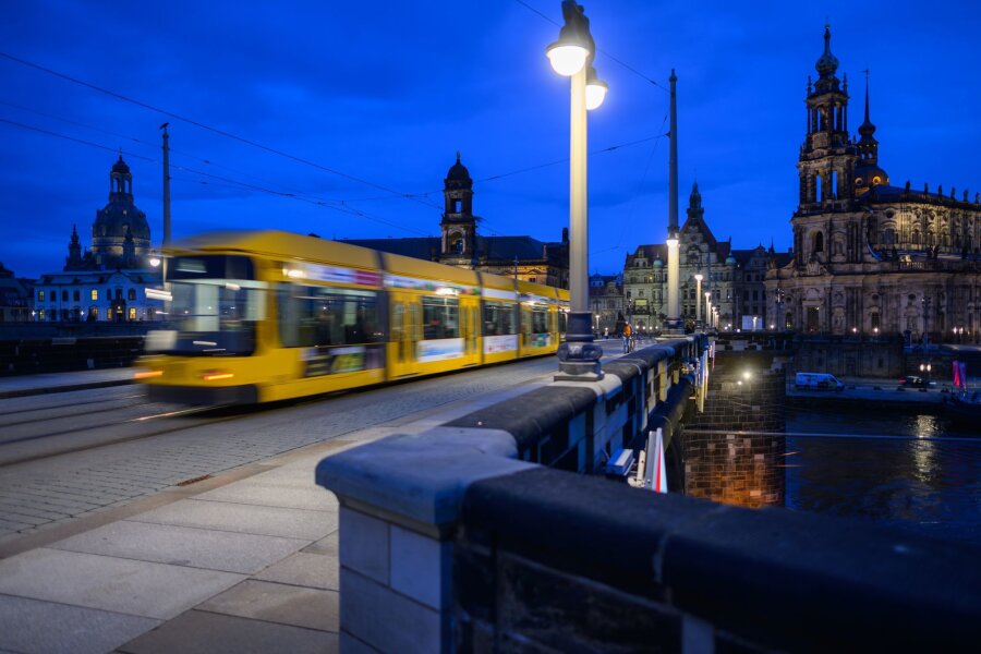 Zusätzliche 337 Millionen Euro für sächsischen ÖPNV - Eine Straßenbahn der Dresdner Verkehrsbetriebe (DVB) fährt am Abend über die Augustusbrücke in die Altstadt.