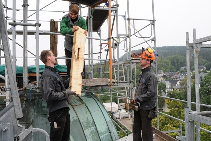 
              <p class="artikelinhalt">Zimmerermeister Ralf Kretschmar sowie seine Kollegen Fabian Josiger und Rigo Heidler (v. l.) auf der Baustelle hoch über den Dächern Scheibenbergs. Dort müssen unter anderem Stützen für die Turmlaterne eingebaut werden, die derzeit noch am Boden steht. </p>
            