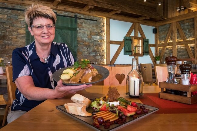Yvonne Reichelt in ihrem Restaurant "Zum Holzwurm" in Seiffen. Sie serviert zwei Gerichte: gratinierten Ziegenkäse (vorn) und Schweinebraten böhmischer Art mit Kartoffelknödeln und Kraut. 