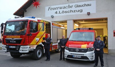 Zwei Feuerwehrautos mit Gesau-Logo - Thomas Müller, Jochen Glös und Christian Wenke (von links) von der Feuerwehr des Glauchauer Ortsteils Gesau präsentieren die neuen Fahrzeuge. 