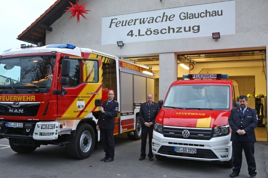 Zwei Feuerwehrautos mit Gesau-Logo - Thomas Müller, Jochen Glös und Christian Wenke (von links) von der Feuerwehr des Glauchauer Ortsteils Gesau präsentieren die neuen Fahrzeuge. 