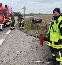 Zwei Männer bei Unfall schwer verletzt - Einsatzleiter Tino Hocke (rechts) und weitere Mitglieder der Freiwilligen Feuerwehr Frankenberg sichern den Unfallort ab. 