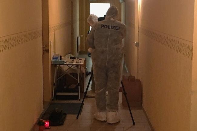 Zweiter Tatverdächtiger stellt sich nach Gewaltverbrechen in Limbach-Oberfrohna - Kriminaltechniker der Polizei sicherten Spuren vor der Tür der Wohnung, in der ein 58-Jähriger tot aufgefunden worden war. Als Zeichen der Trauer hat jemand Grablichter neben die Tür gestellt.