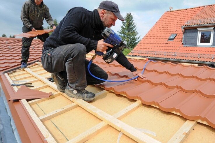 "Zwergenland"-Anbau wächst - Mitarbeiter Ingo Zehmisch und Matthias Kunze (v. l.) vom Dachdeckerbetrieb Mirko Heine aus Wernsdorf decken zurzeit das Dach auf dem Anbau der Kita Langenleuba-Oberhain. 