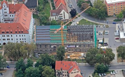 Zwickau: Sanierung des Kornhauses geht planmäßig voran - Das Kornhaus aus der Luft: Links ist das Dach fertig saniert, der Mittelteil ist gerade im Bau und rechts der alte Zustand des Daches.
