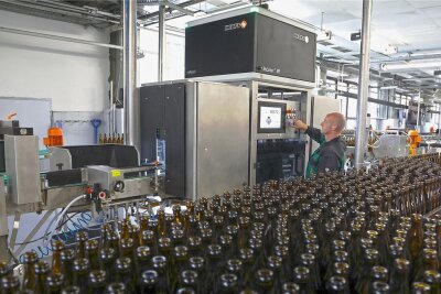 Zwickauer Brauerei investiert trotz Corona-Krise - Mitarbeiter Steffen Krämer bedient den neuen Flascheninspektor, der gut 30.000 Mehrwegflaschen pro Stunde vor den Befüllen penibel auf vollständige Sauberkeit, Risse und andere Beschädigungen überprüft. 