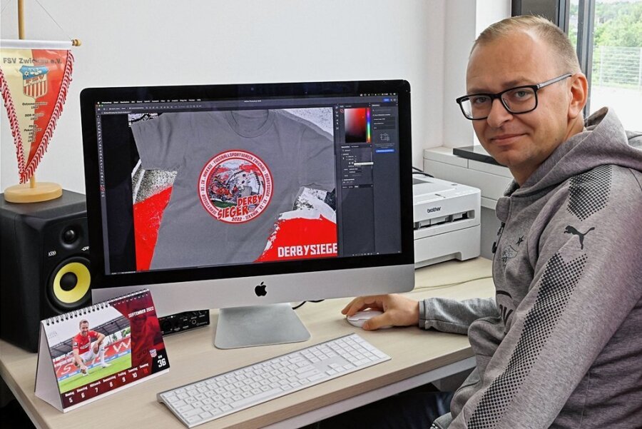 Zwickauer Fans zeigen Stolz über Sieg in Aue mit "Derbysieger"-Shirt - FSV-Pressesprecher Daniel Sacher zeigt am PC-Bildschirm, wie das Derbysieger-Shirt aussieht. Ab Freitag kommt es in den Fanshop. 