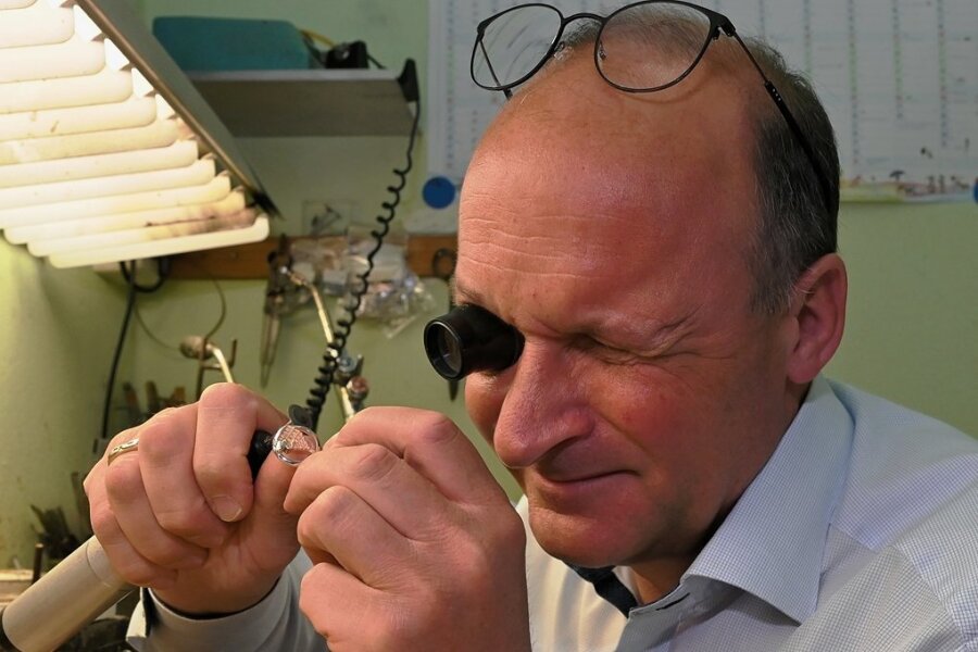 Andreas Lindner, Inhaber von "Juwelier Uhlmann" nimmt das neueste Stück aus der Zwickau-Kollektion unter die Lupe. Er hat es fertigen lassen, weil er seine Stadt gern mag. Fotos: Ralf Wendland (3)