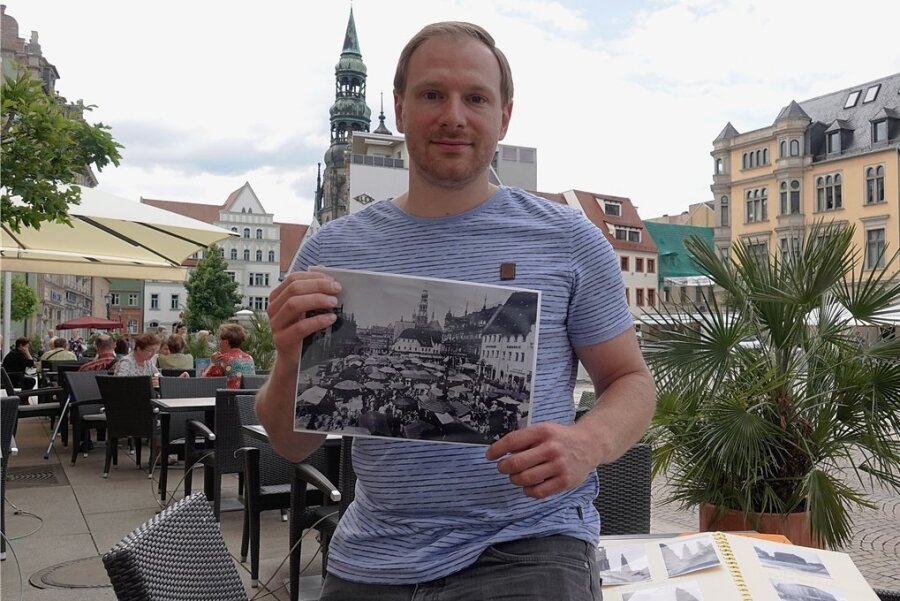 Christian Ringer zeigt auf dem Hauptmarkt, wie sein Fotoprojekt funktioniert: Er veröffentlicht historische Aufnahmen und zum Vergleich aktuelle Bilder derselben Orte. 