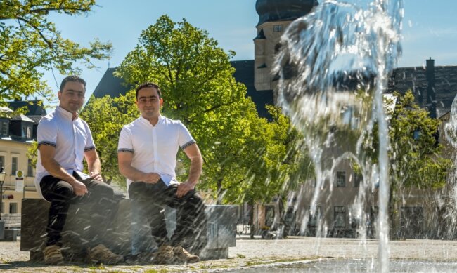 Zwillingsbrüder finden im Erzgebirge eine zweite Heimat - Die aus Afghanistan stammenden Zwillinge Sultan (l.) und Sana Kakar sitzen am Brunnen auf dem Marienberger Markt. 