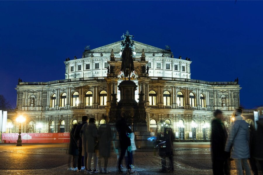 Zwischen Warnung und Zurückhaltung - was sagt die Kultur in Sachsen im Wahljahr 2024? - Touristen stehen am Abend auf dem Theaterplatz vor der Semperoper.
