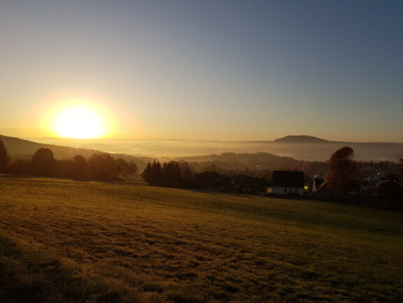 Sonnenaufgang in Thermalbad Wiesenbad OT Sch&ouml;nfeld mit Blick nach Annaberg-Buchholz. Der P&ouml;hlberg &uuml;ber den Wolken.