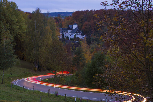 &bdquo;Blick zum Schloss Rauenstein&ldquo;, eingebettet im bunten Herbstwald. 
